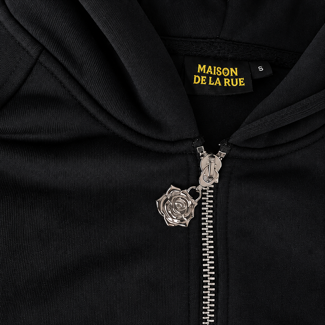 Signature Hoodie Product V4 Black. Detailansicht des schwarzen Maison De La Rue Hoodies am Kragen und Reißverschluss.
