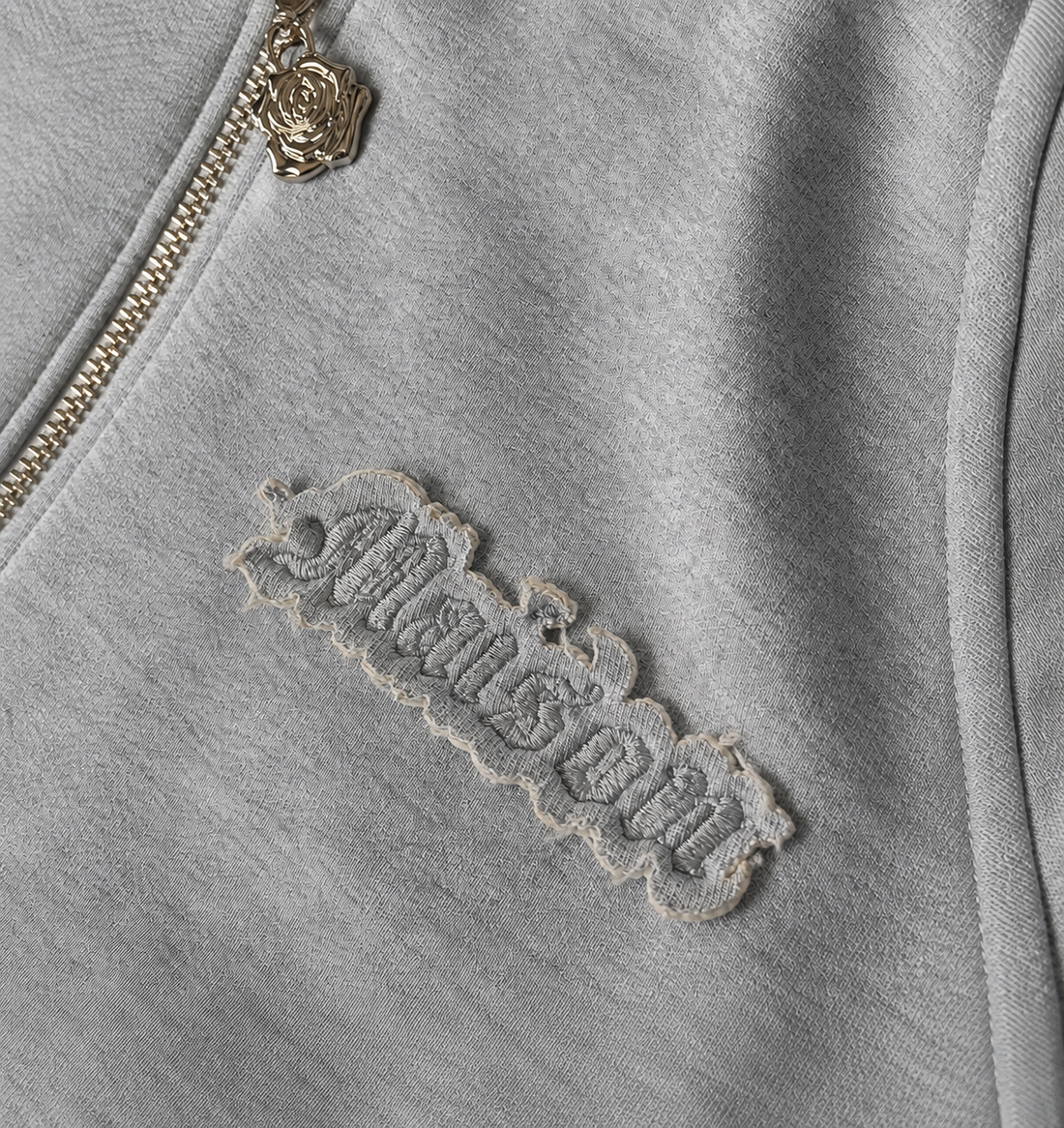 Signature Hoodie Product V5 Grey Melange. Detailansicht der Tasche und des grauen Stoffes.